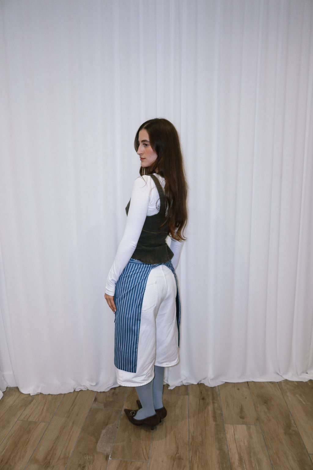 girl wearing a blue and white striped cotton apron.