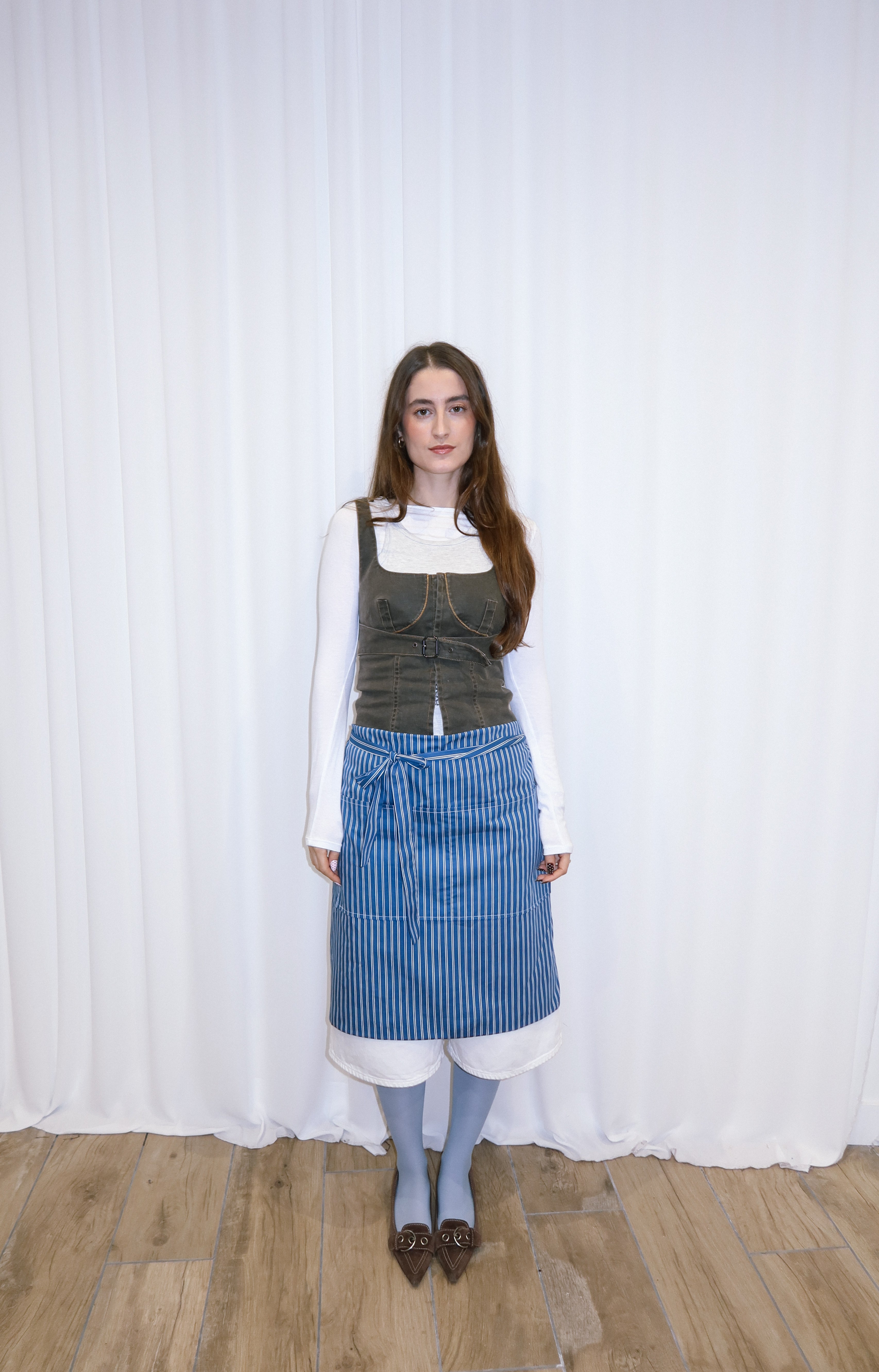 girl wearing a blue and white striped cotton apron.